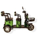 green three-seater electric rickshaw with a black frame and handlebars, featuring padded seats, a front basket, and rear passenger footrests