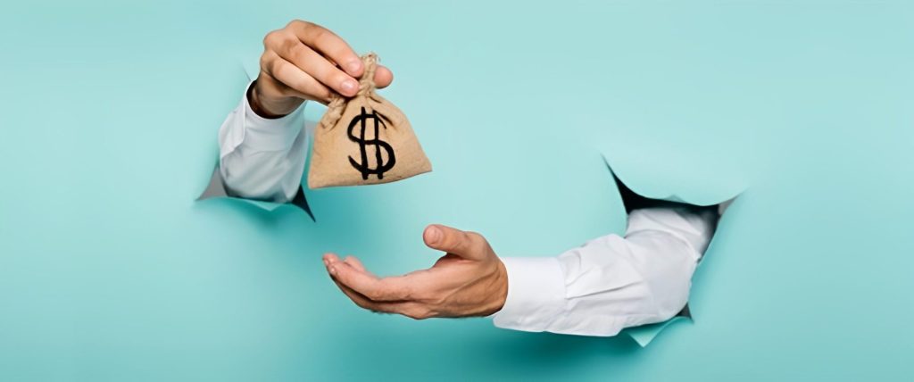 Hand holding cash, illustrating the higher cost of all-terrain mobility scooters