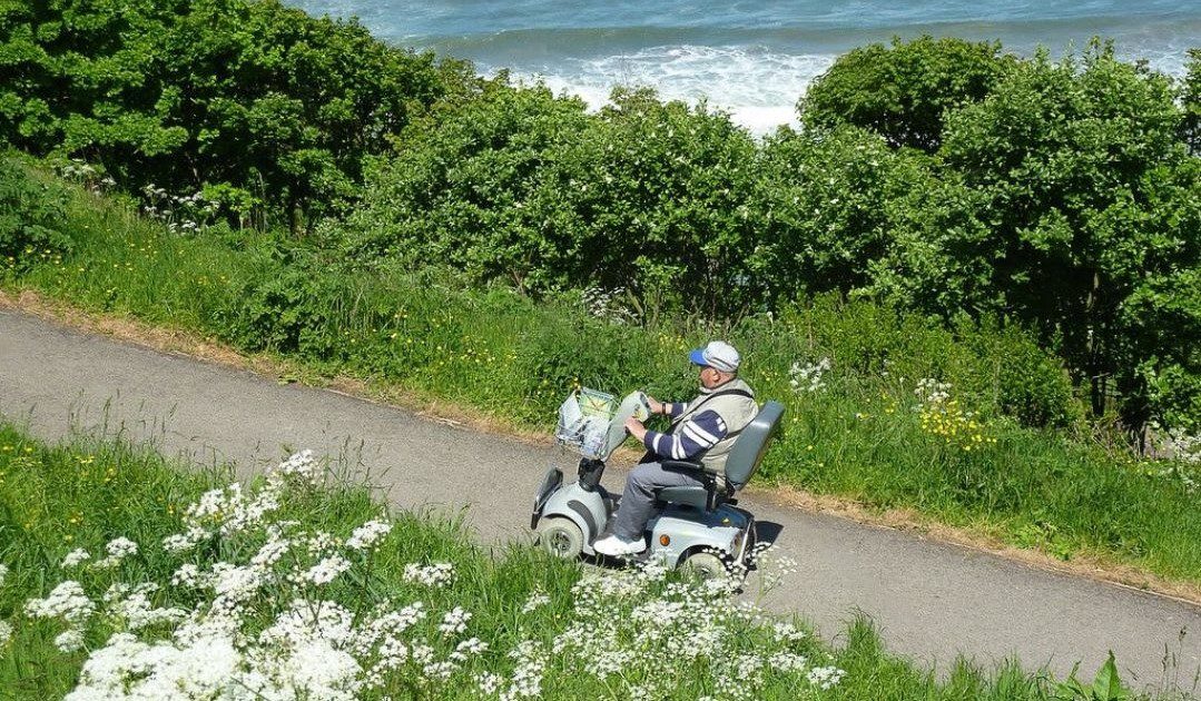 Mobility scooter climbing uphill on a paved road