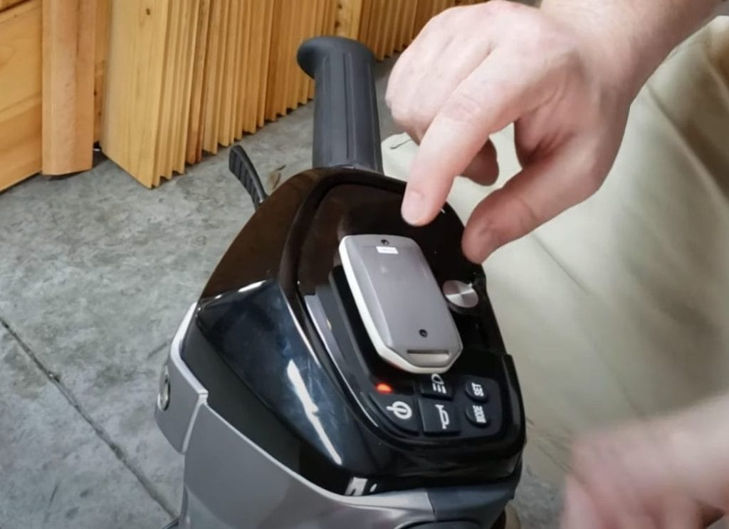 Remote fob held close to the EV Rider TeQno scooter to prepare for pairing