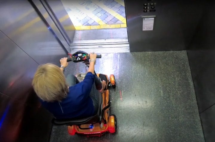 Lightweight auto-folding mobility scooter being lifted