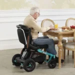 Elderly man using the Golden Ally GP303 power chair while eating at a dining table indoors