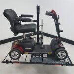 Side view of a 4 wheel scooter held by the US218 automatic hold down arm