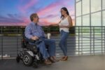 Couple outdoors at sunset with the Merits Ultra power wheelchair